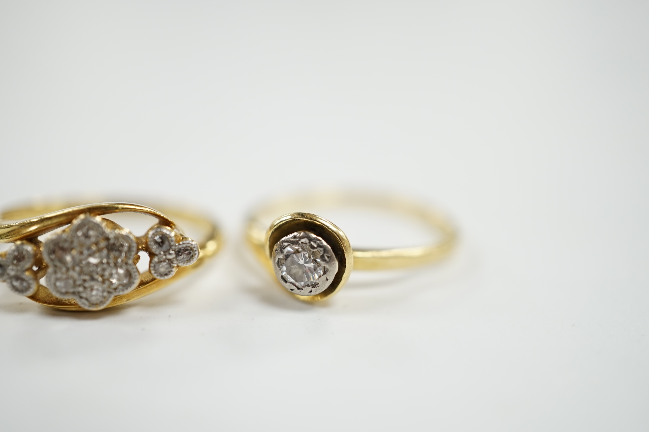 An 18ct, plat and millegrain set triple diamond cluster crossover ring, size K and an 18ct gold and illusion set solitaire diamond ring, size L, gross weight 5.1 grams. Condition - fair to good